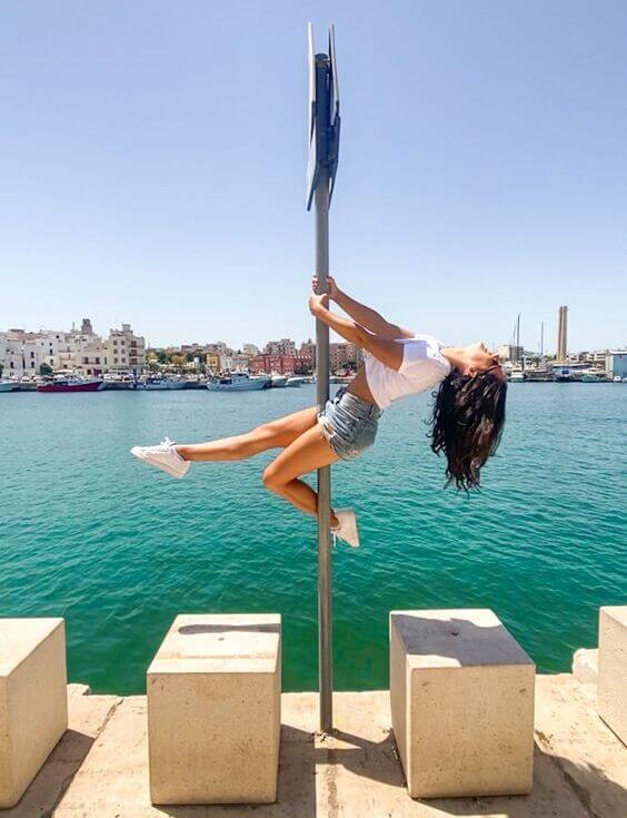 pole dancing girl dancer outdoors sea street sign